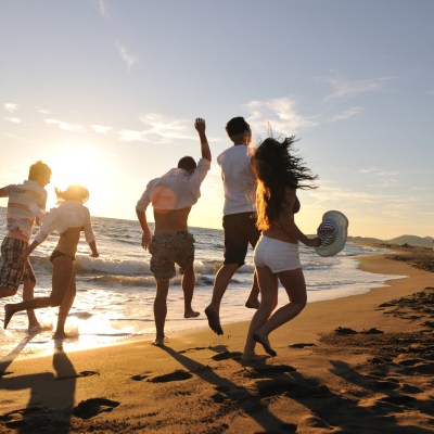 a group of people standing on top of a sandy beach