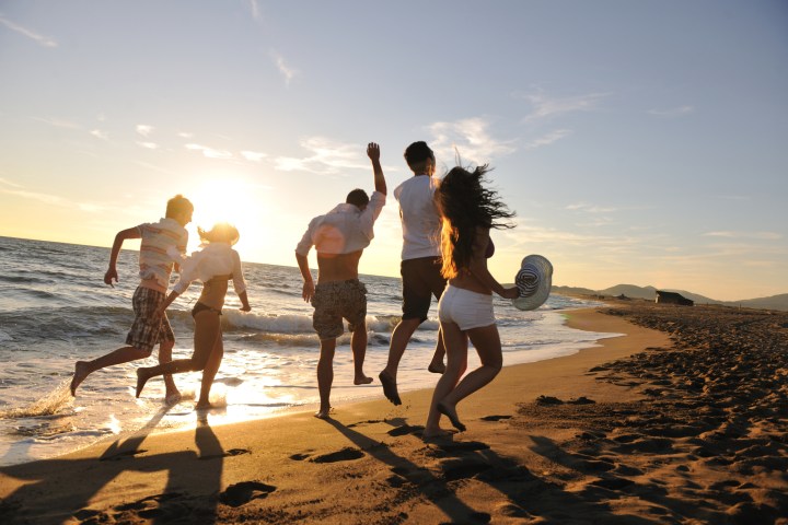 a group of people standing on top of a sandy beach